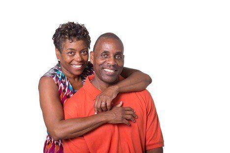 A woman is hugging a man from behind on a white background.